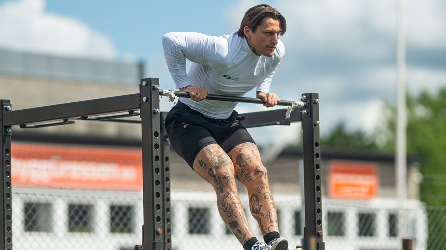 Mies treenaa ulkona tekemss muscle-upia.